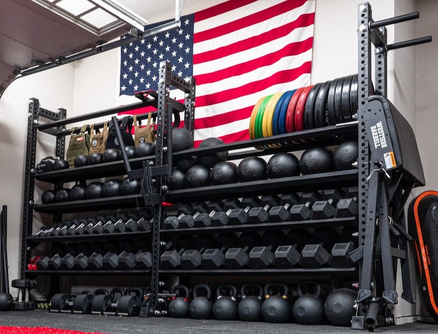 storage rack of dumbbells, weight plates, and kettlebells