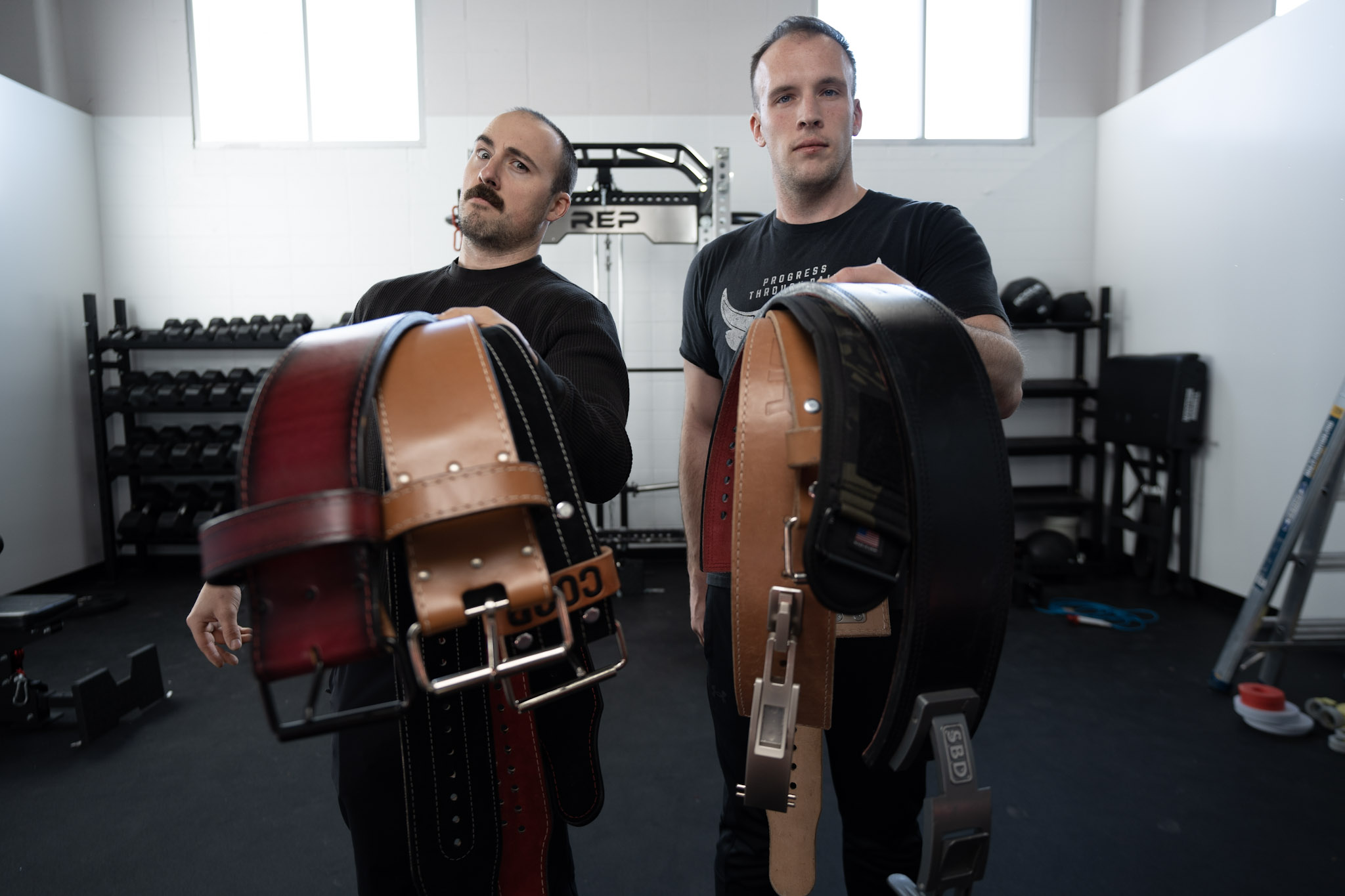 Holding a variety of weightlifting belts