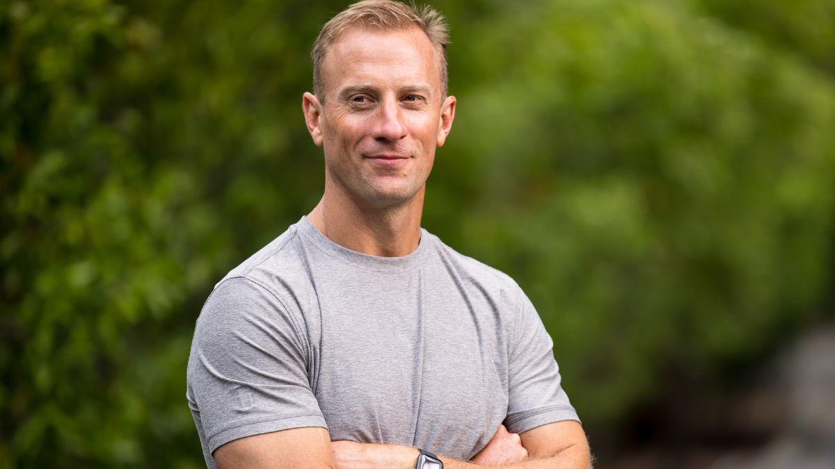 CrossFit CEO Dan Faul crosses his arms, wearing a grey t-shirt