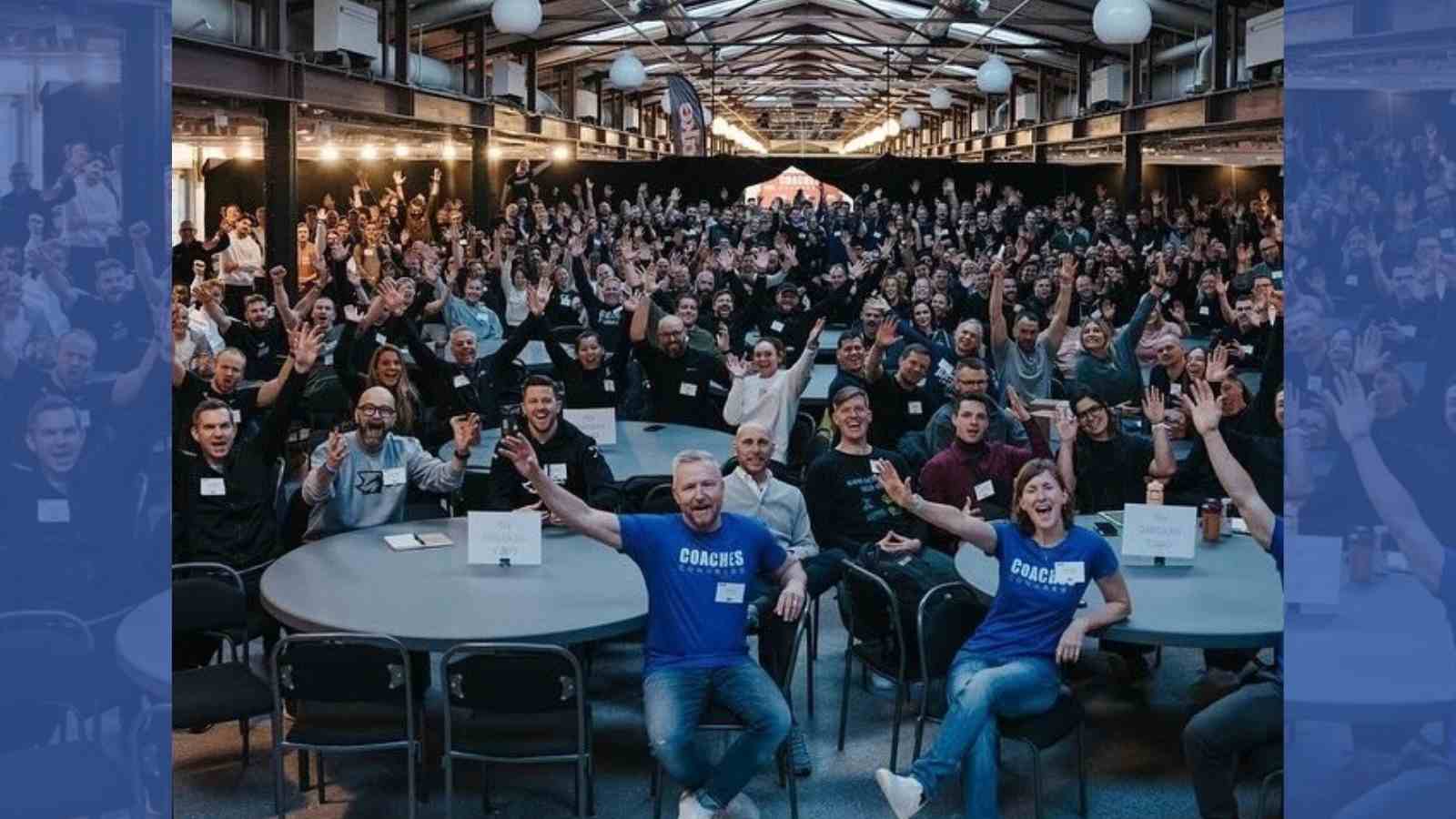 A large CrossFit audience sits at tables