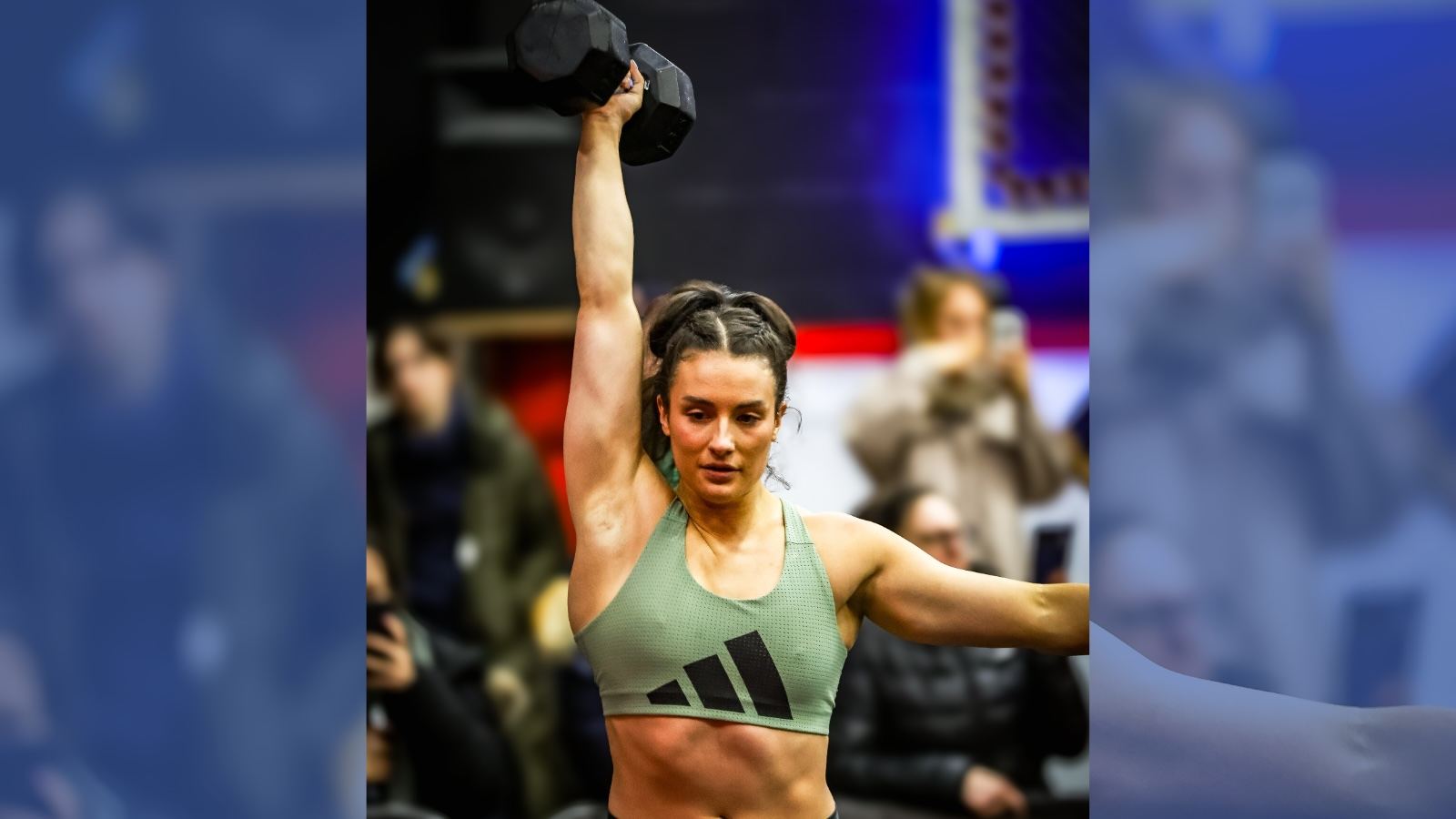 Ella Wilkinson holds up a dumbbell at a competition